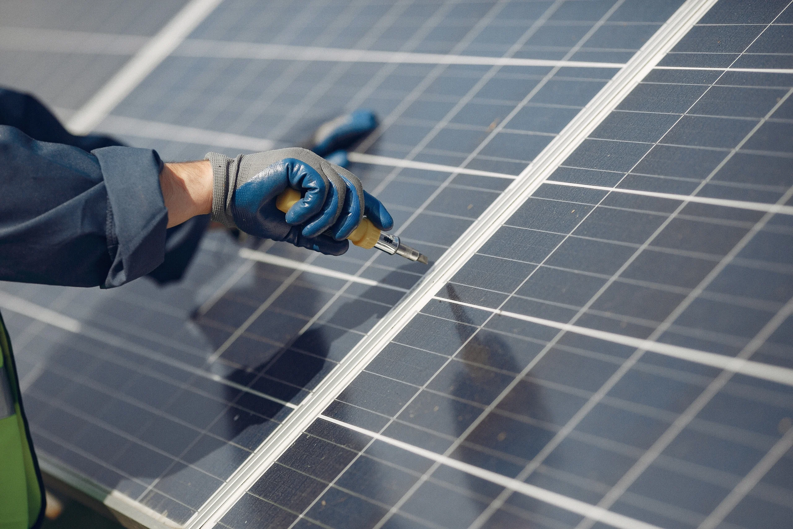 man with white helmet near solar panel