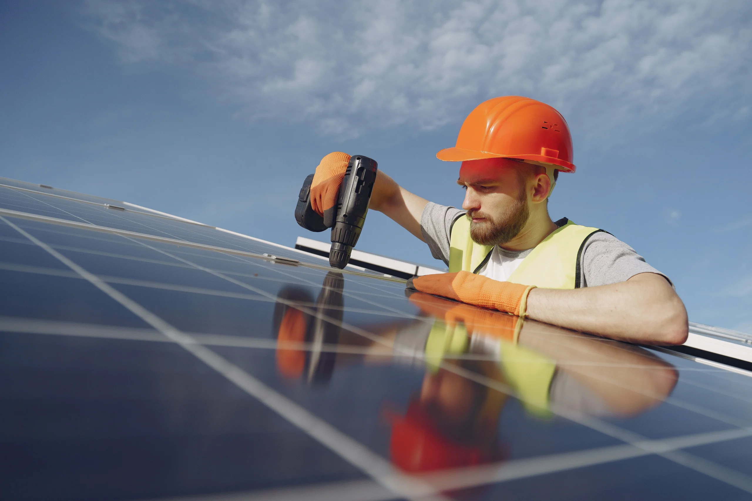 Person repairing solar panel while using a drill