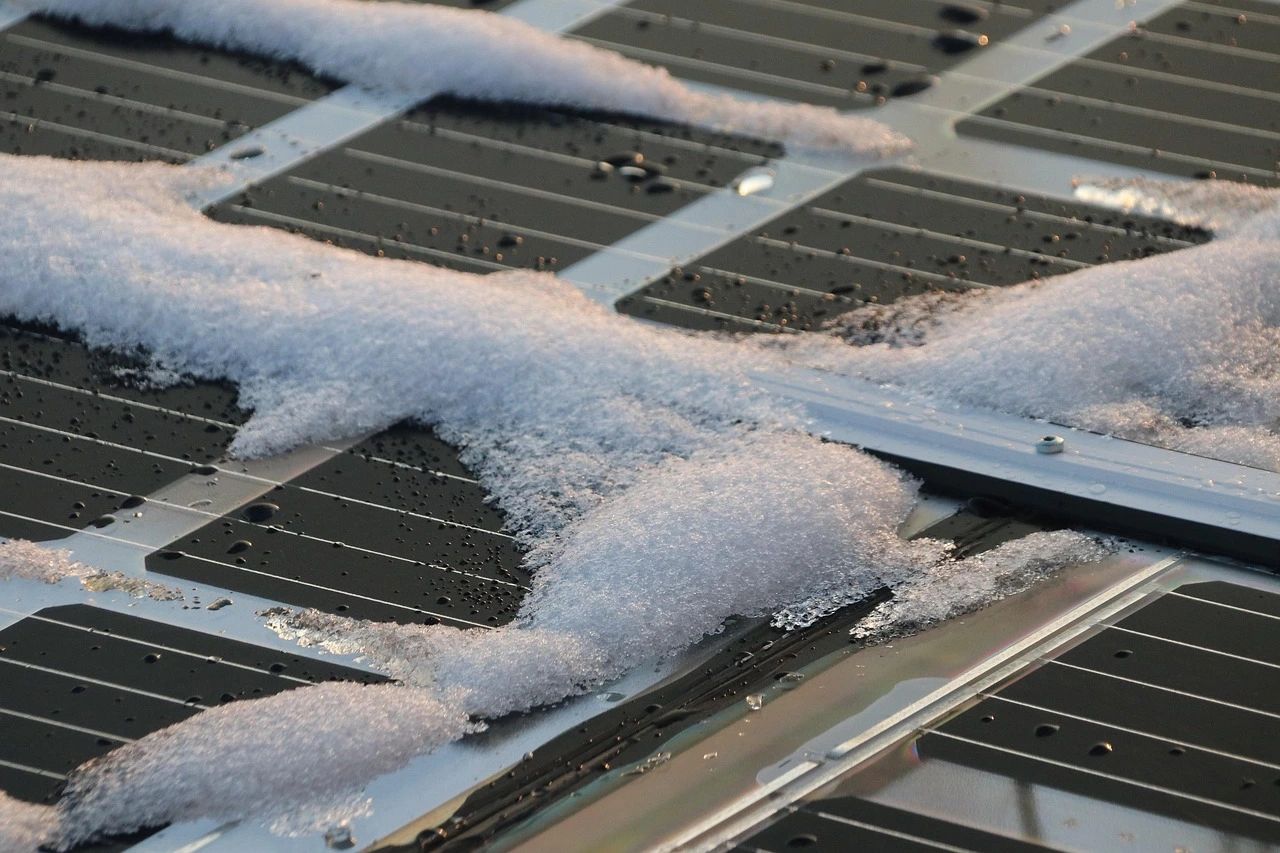 Snow on solar panels signifying the need for maintenance.