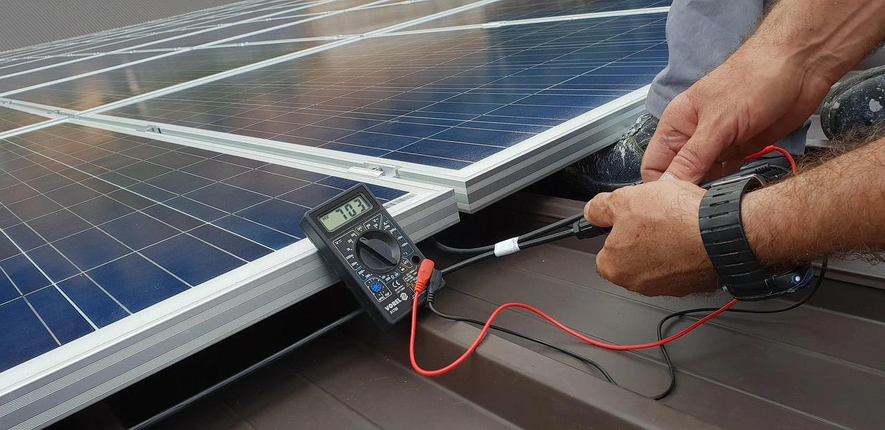 Technician maintaining and servicing the solar panel through tests.