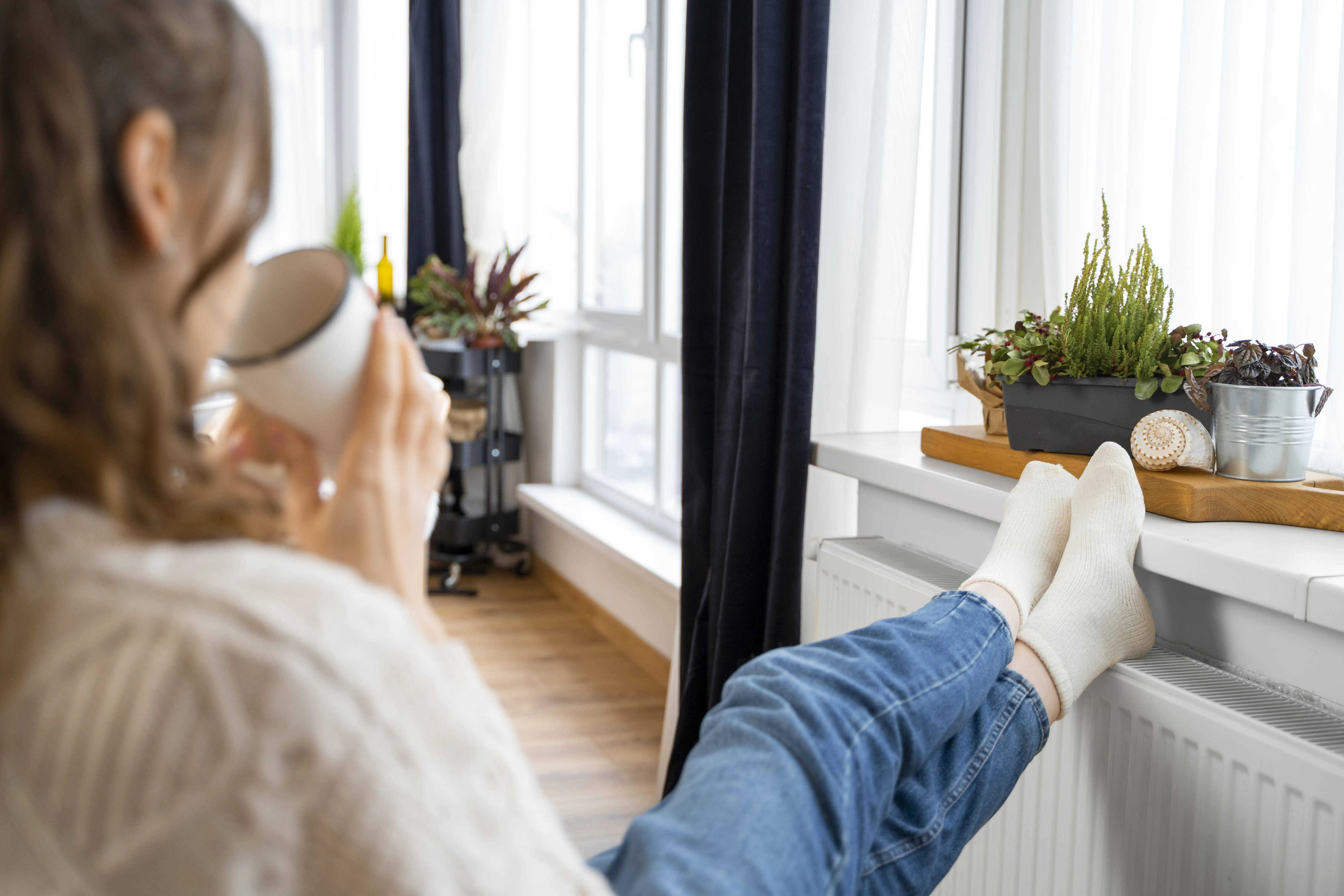 Close up of woman sitting near heated radiator