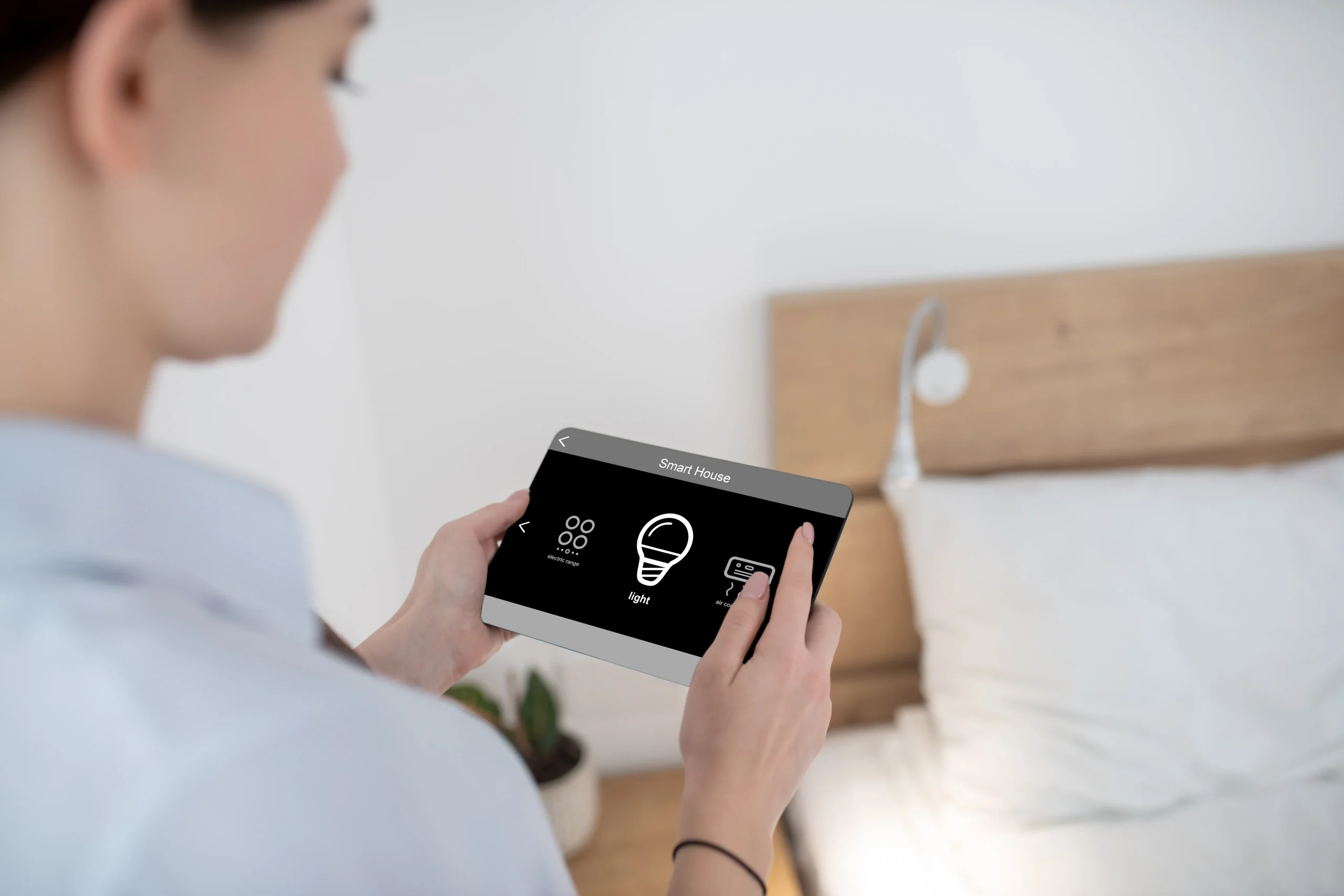 Person using a smart home control tablet, showing how smart meters connect with home devices for better energy management.