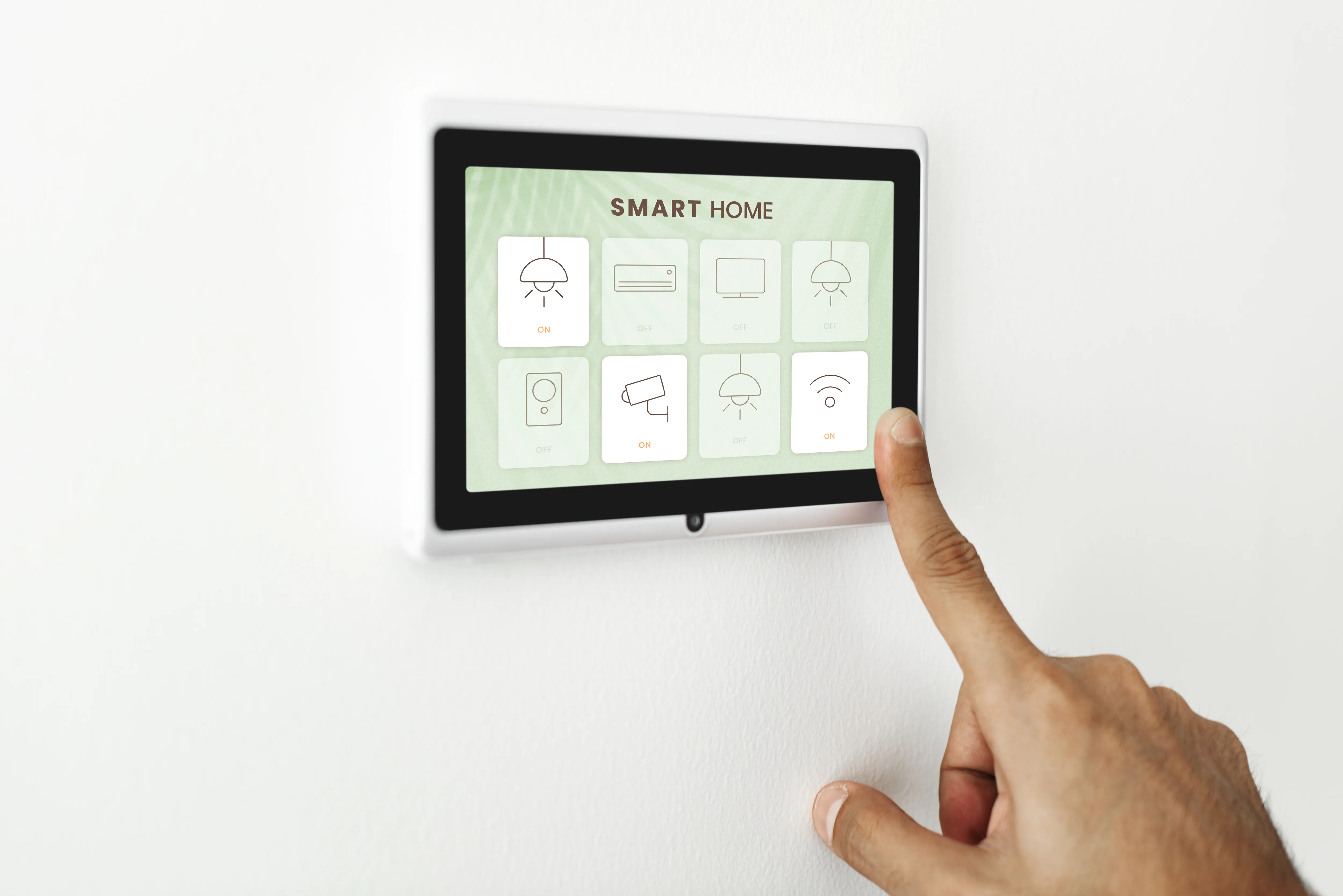 A person selects a control on a wall-mounted smart home panel that manages multiple household devices.
