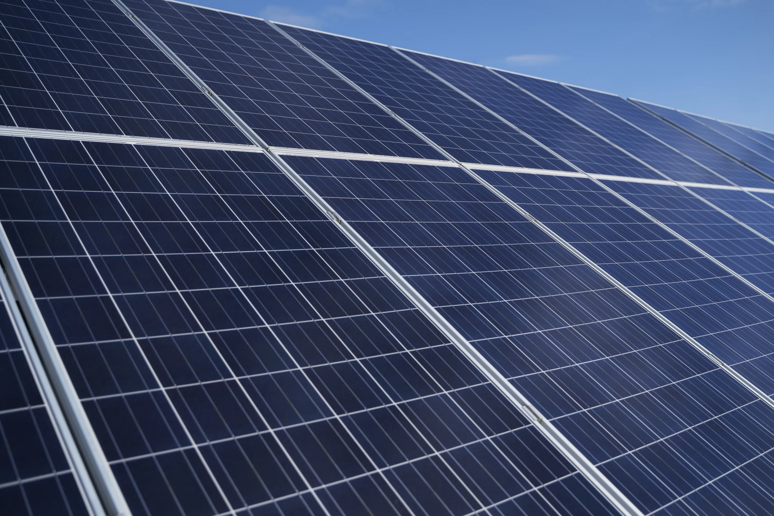 Close-up of rooftop solar panels under sunlight, showing the renewable energy smart meters help