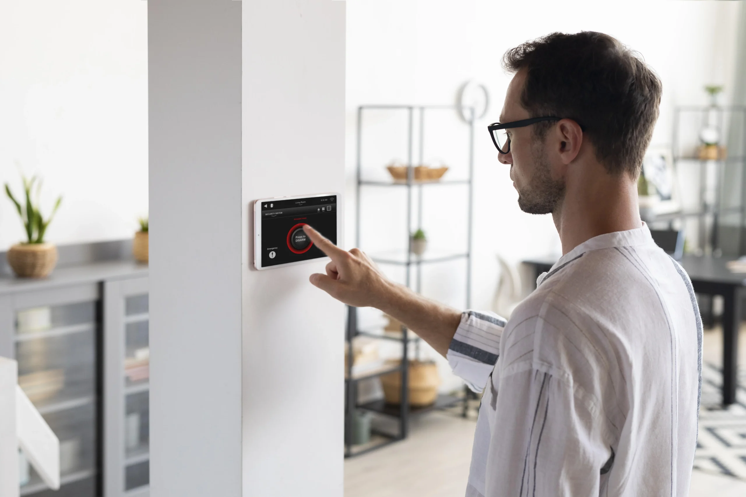 Person adjusting a smart thermostat on the wall, showing how UK solar homes can automate heating to save energy.