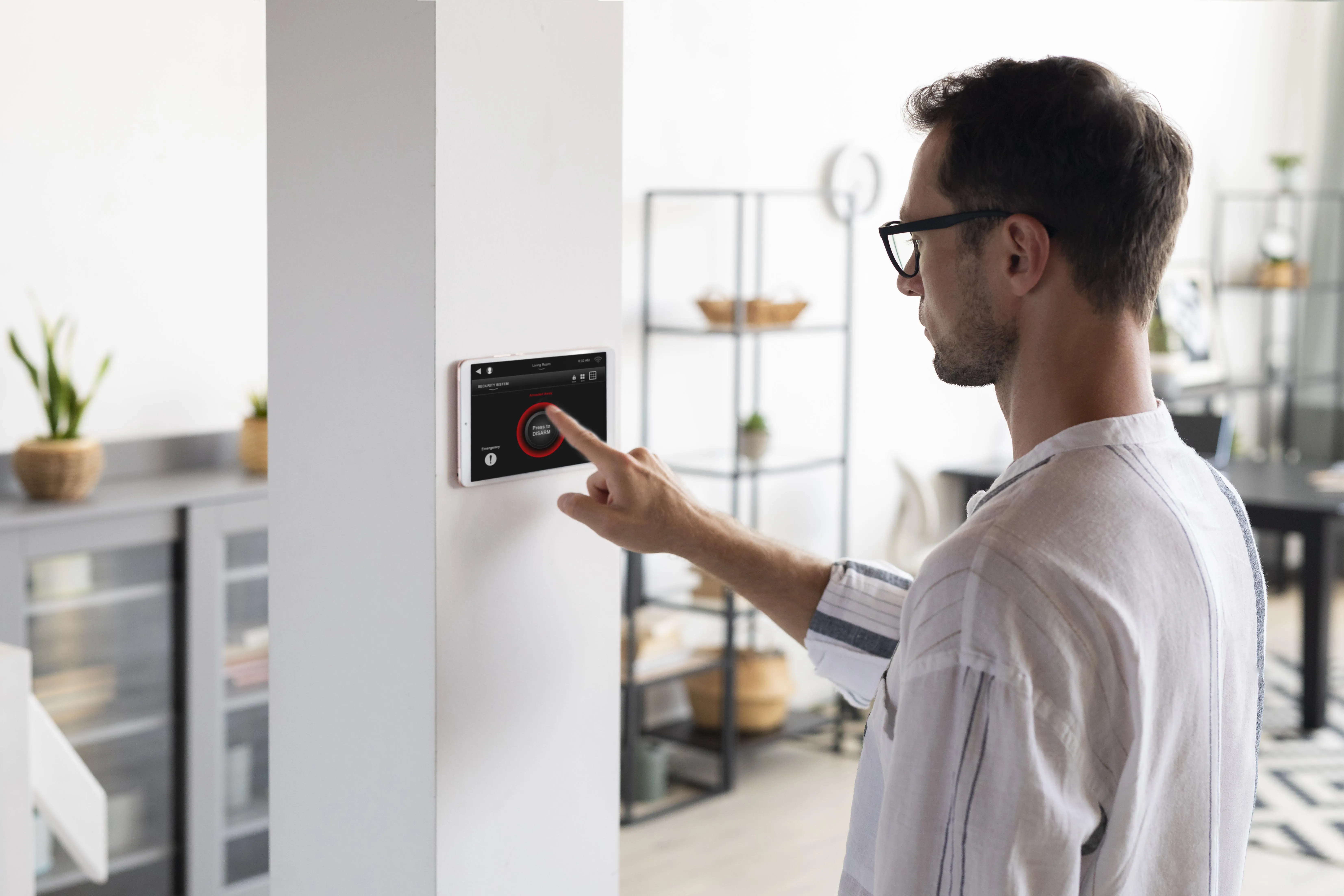 Person adjusting a smart thermostat on the wall, showing how UK solar homes can automate heating to save energy.