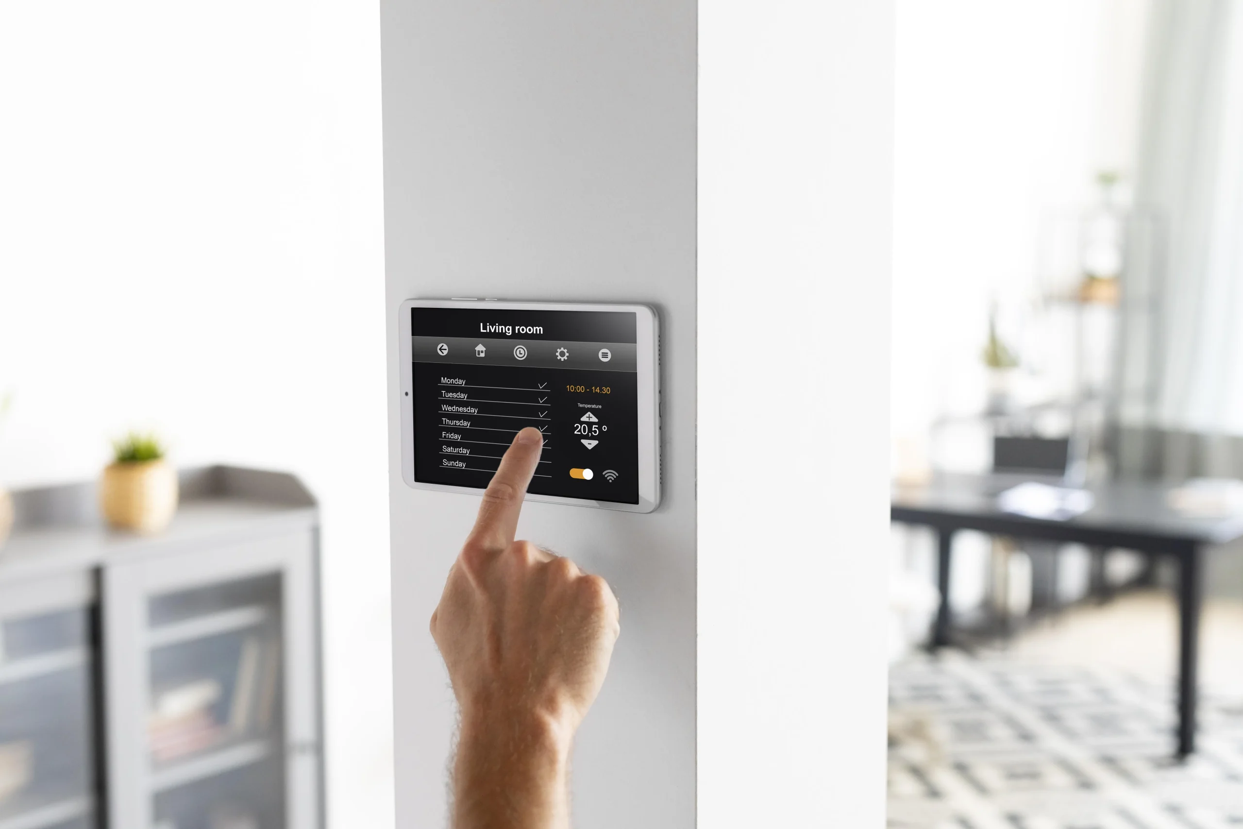 Hand adjusting a smart home control panel, highlighting that smart technology can bring convenience but also reliability challenges.