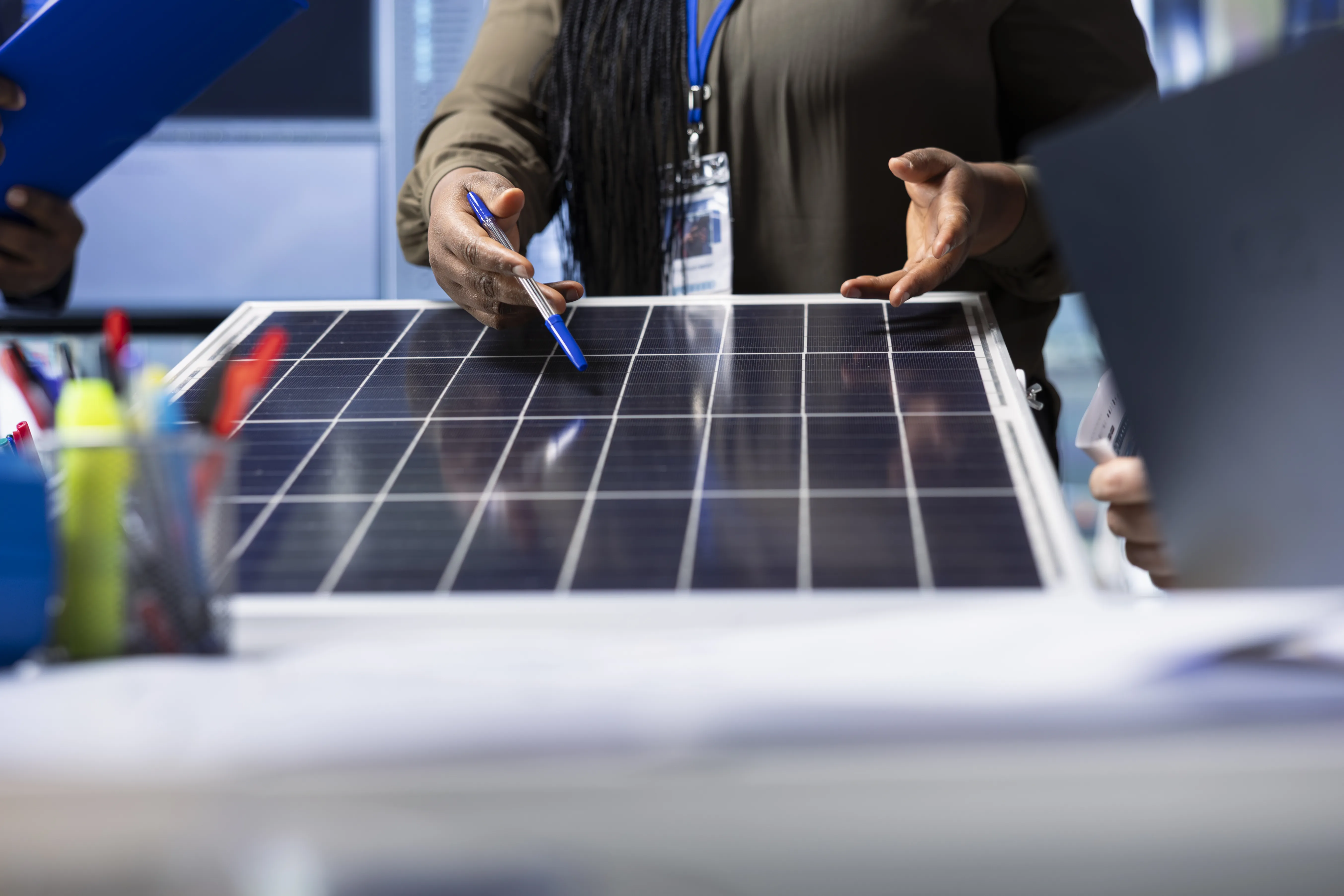 Engineers reviewing a solar panel up close during a discussion on advanced photovoltaic technology.