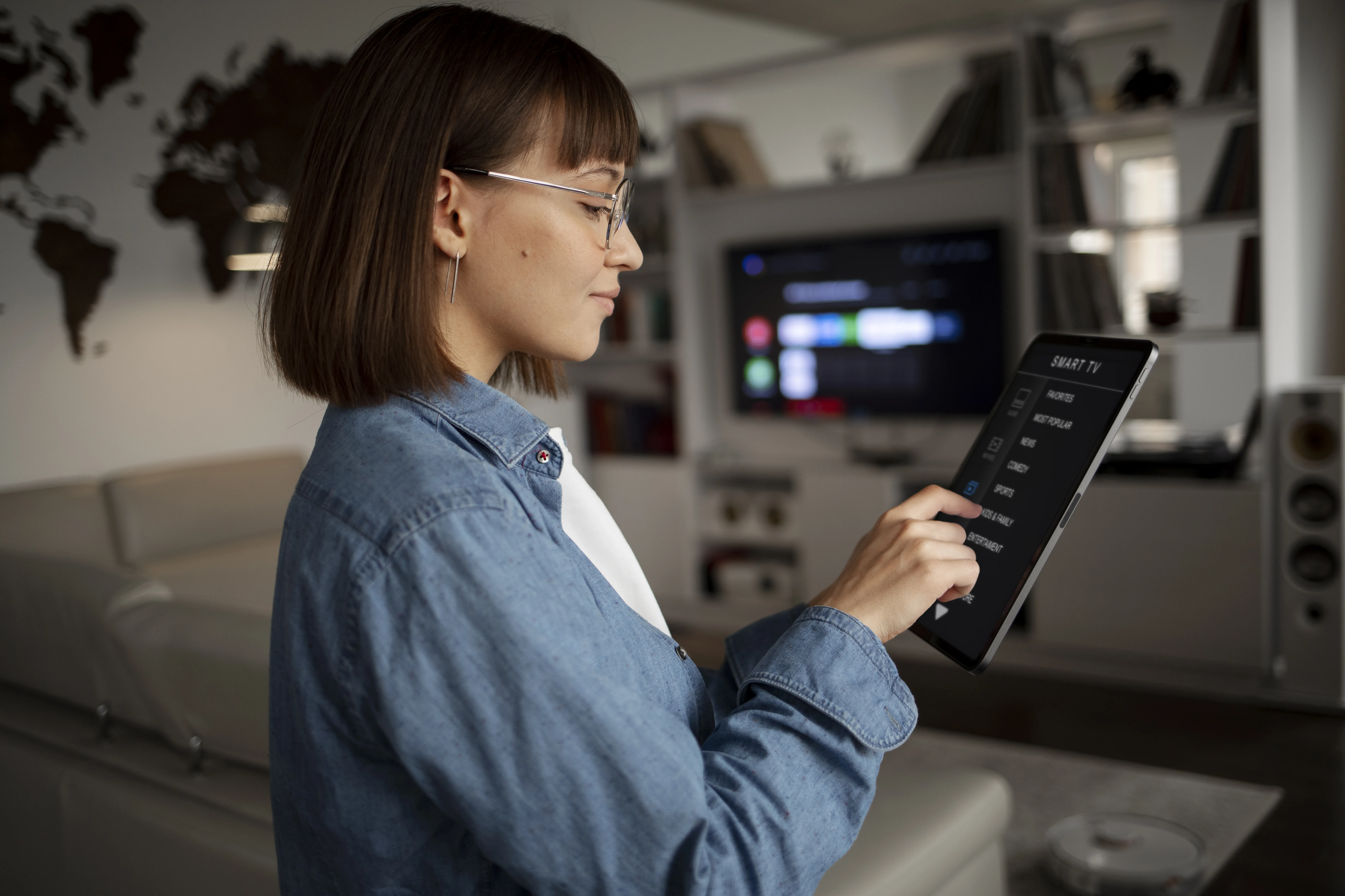 A lady checks smart home controls on a tablet, showing how multiple devices can be managed from one system.