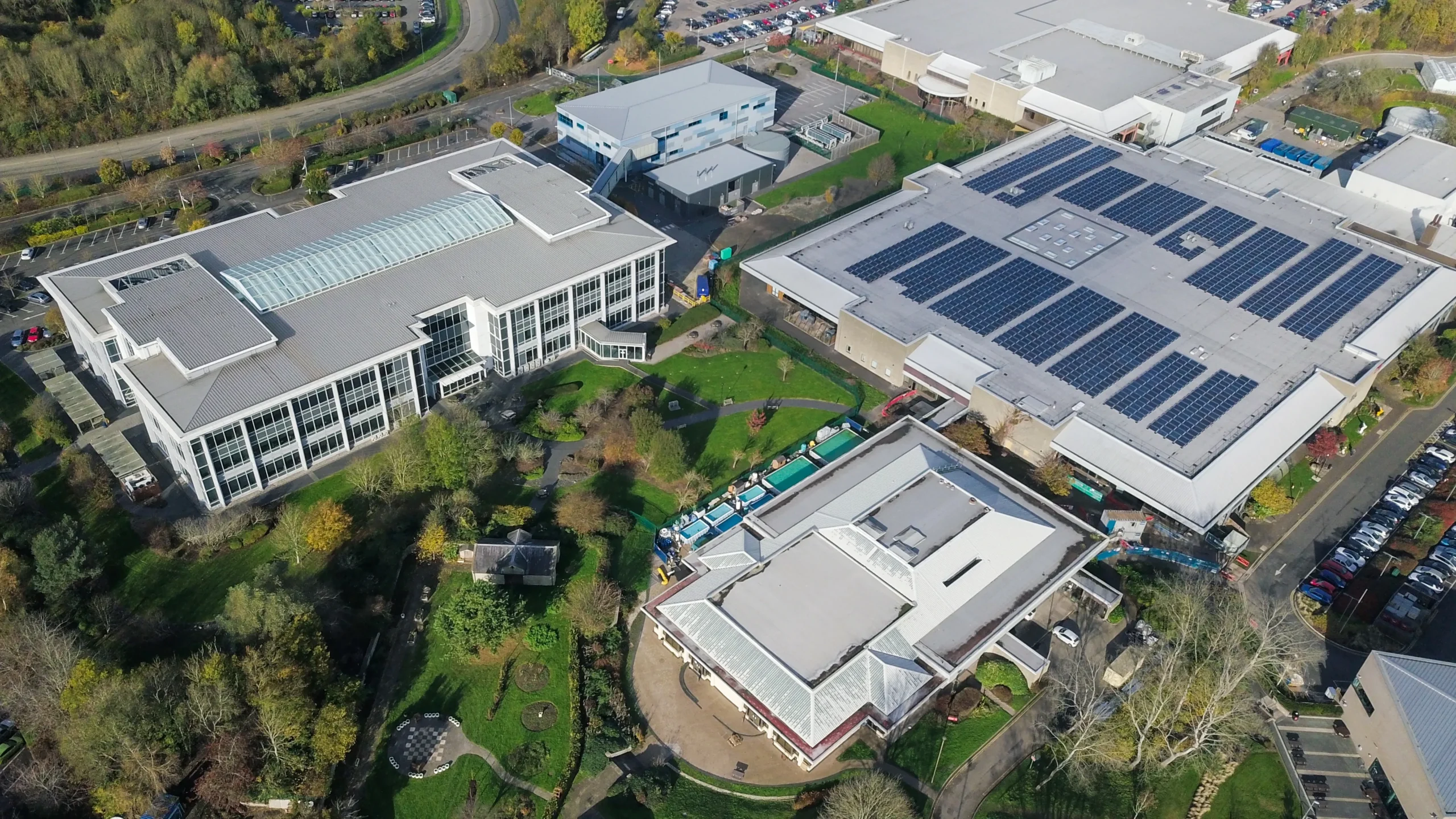 Large warehouse facility with extensive rooftop solar panels installed, demonstrating on-site solar generation for commercial energy use and cost reduction.