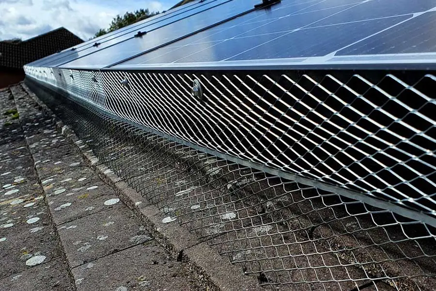 Bird proofing mesh installed around solar panels on a roof