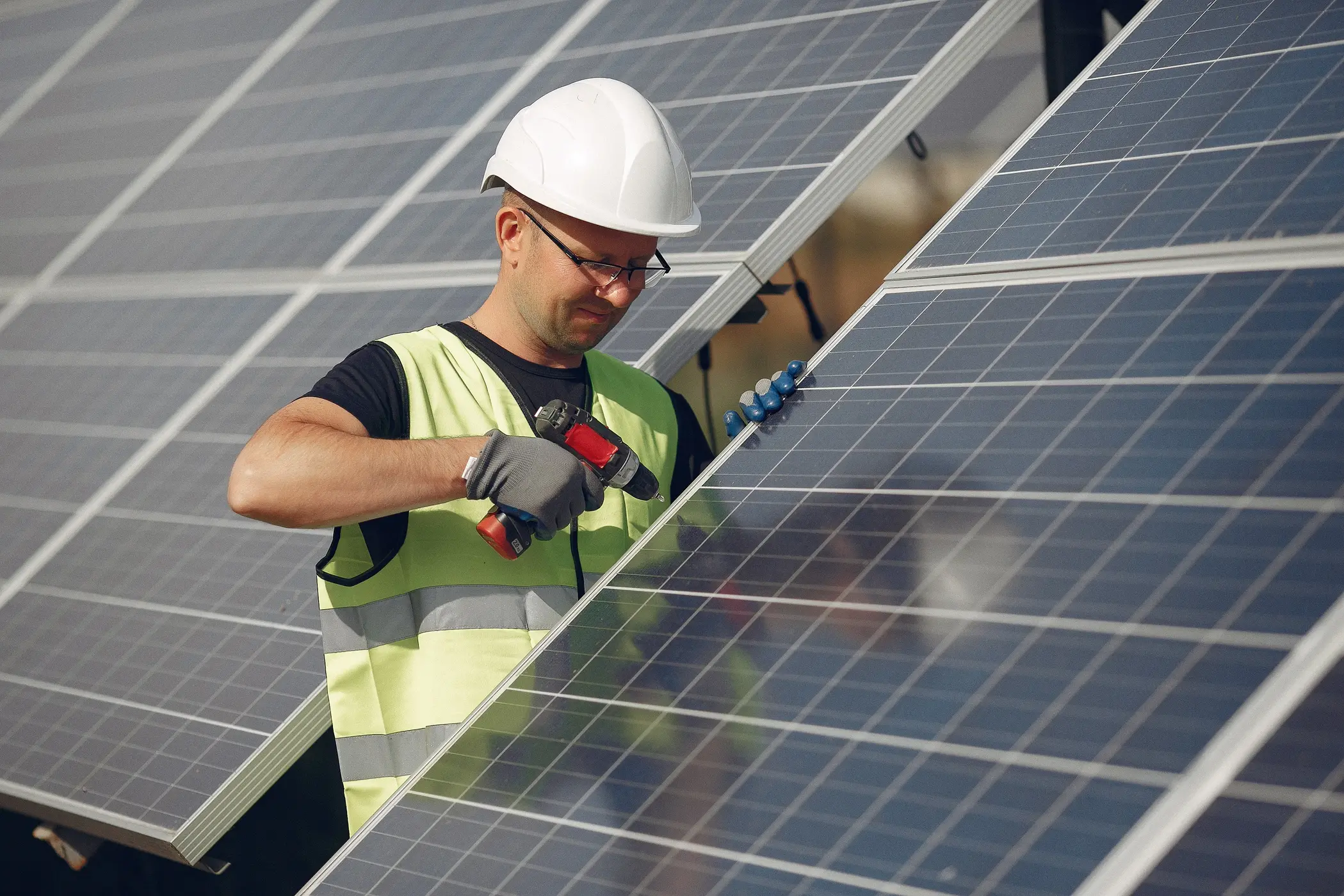 Solar technician inspecting and servicing rooftop solar panels, illustrating when ageing panels may need replacement, upgrades, or maintenance.