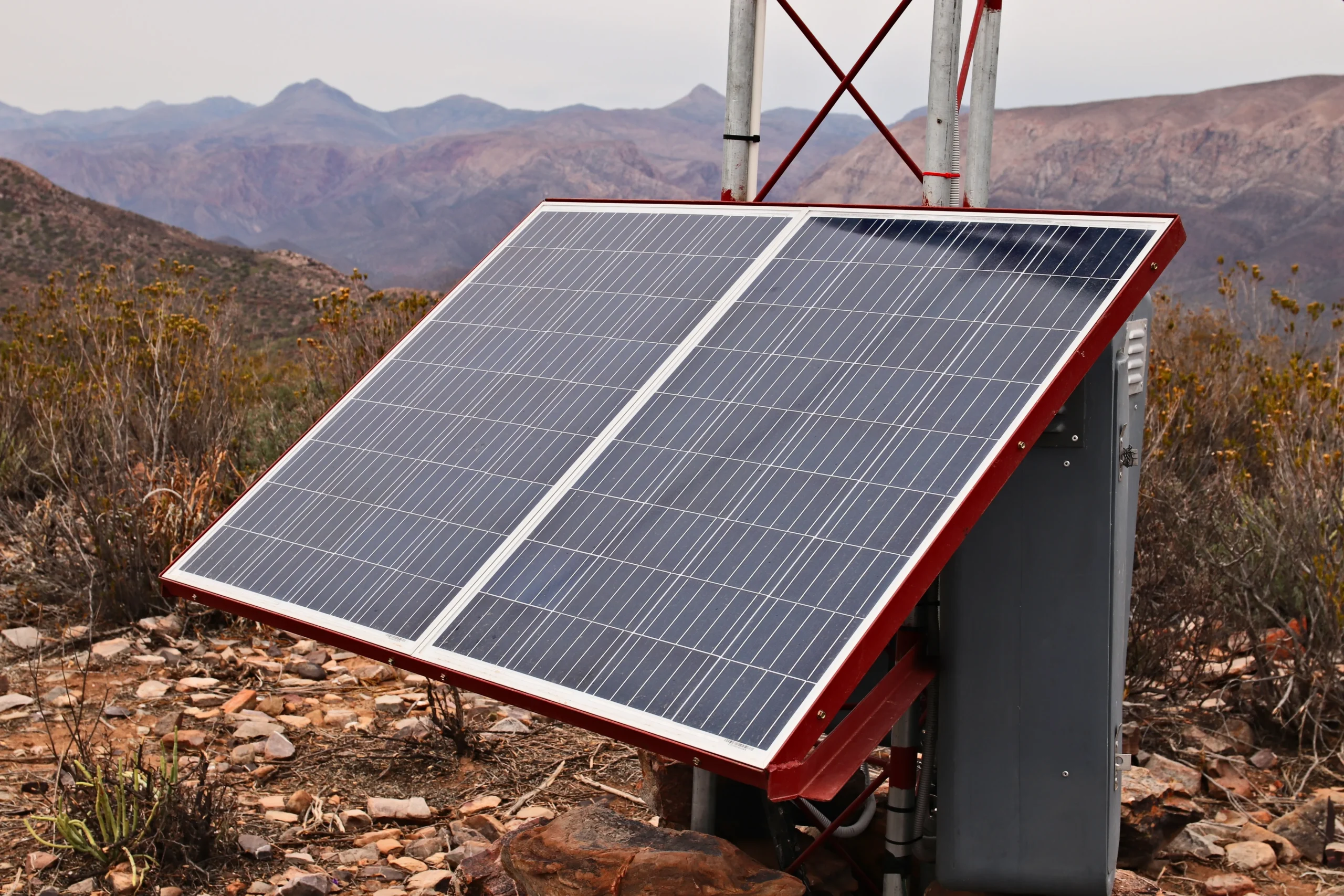 Standalone solar panel system with integrated battery unit in a remote setting, illustrating energy storage and off-grid power use.