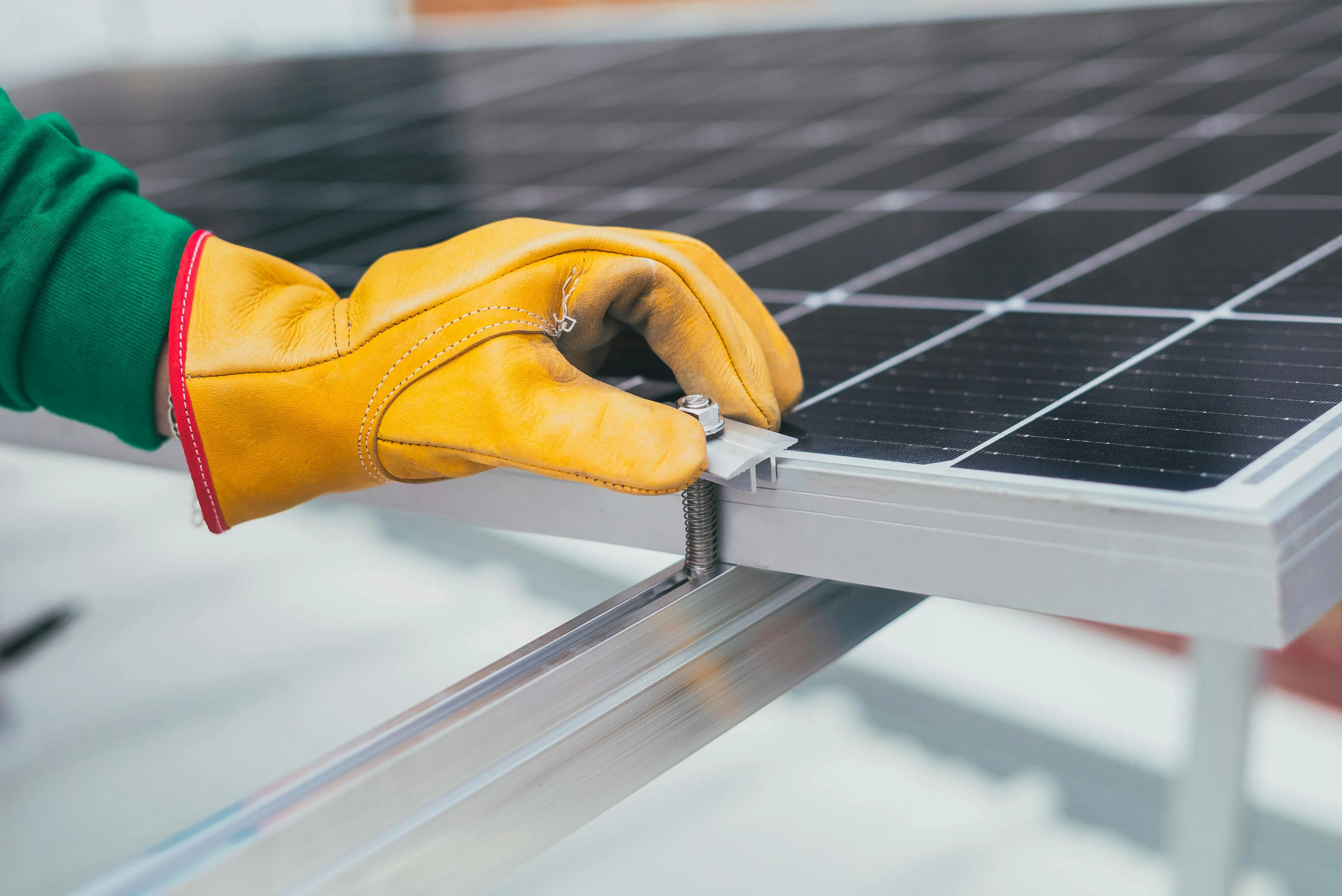 Close-up of a solar panel being installed onto a mounting rail, illustrating how existing solar systems can be expanded later with compatible hardware and proper planning.