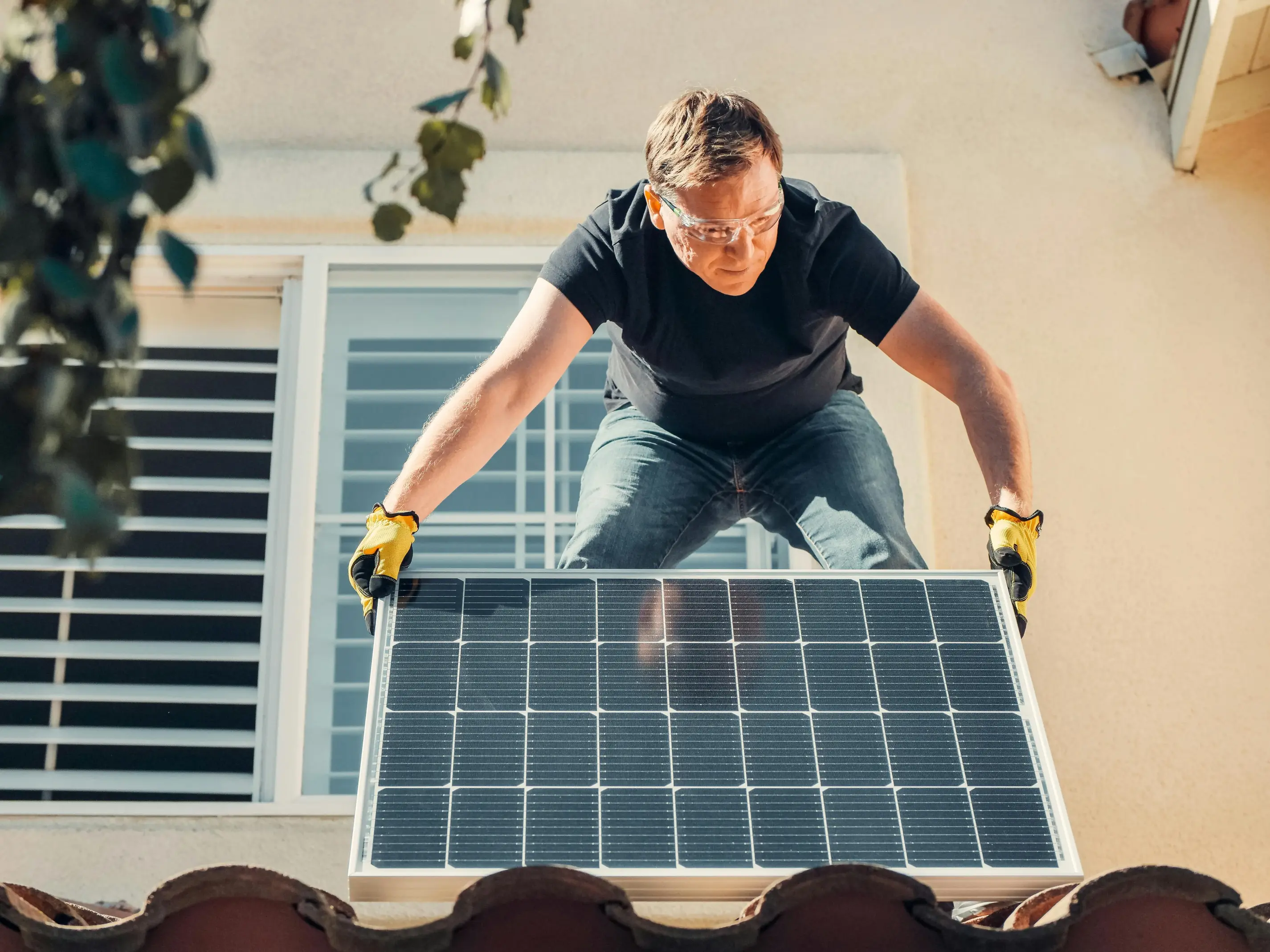 Technician installing an additional solar panel on a residential roof, representing the planning, compatibility checks, and system upgrades involved in safely expanding solar capacity.