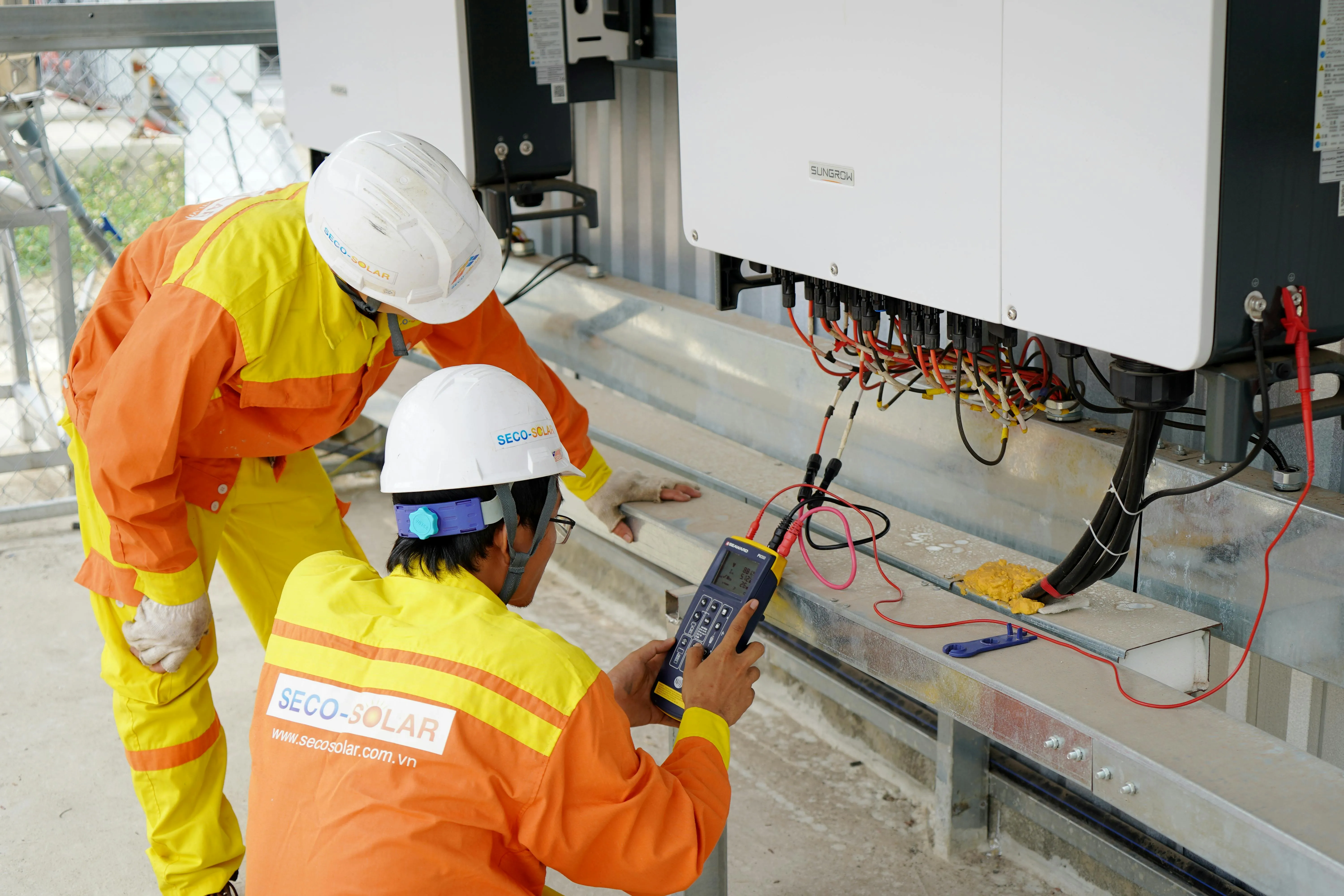 Solar technicians testing and upgrading inverter equipment to improve system efficiency, enable future expansion, and ensure compatibility with modern solar and battery storage setups.