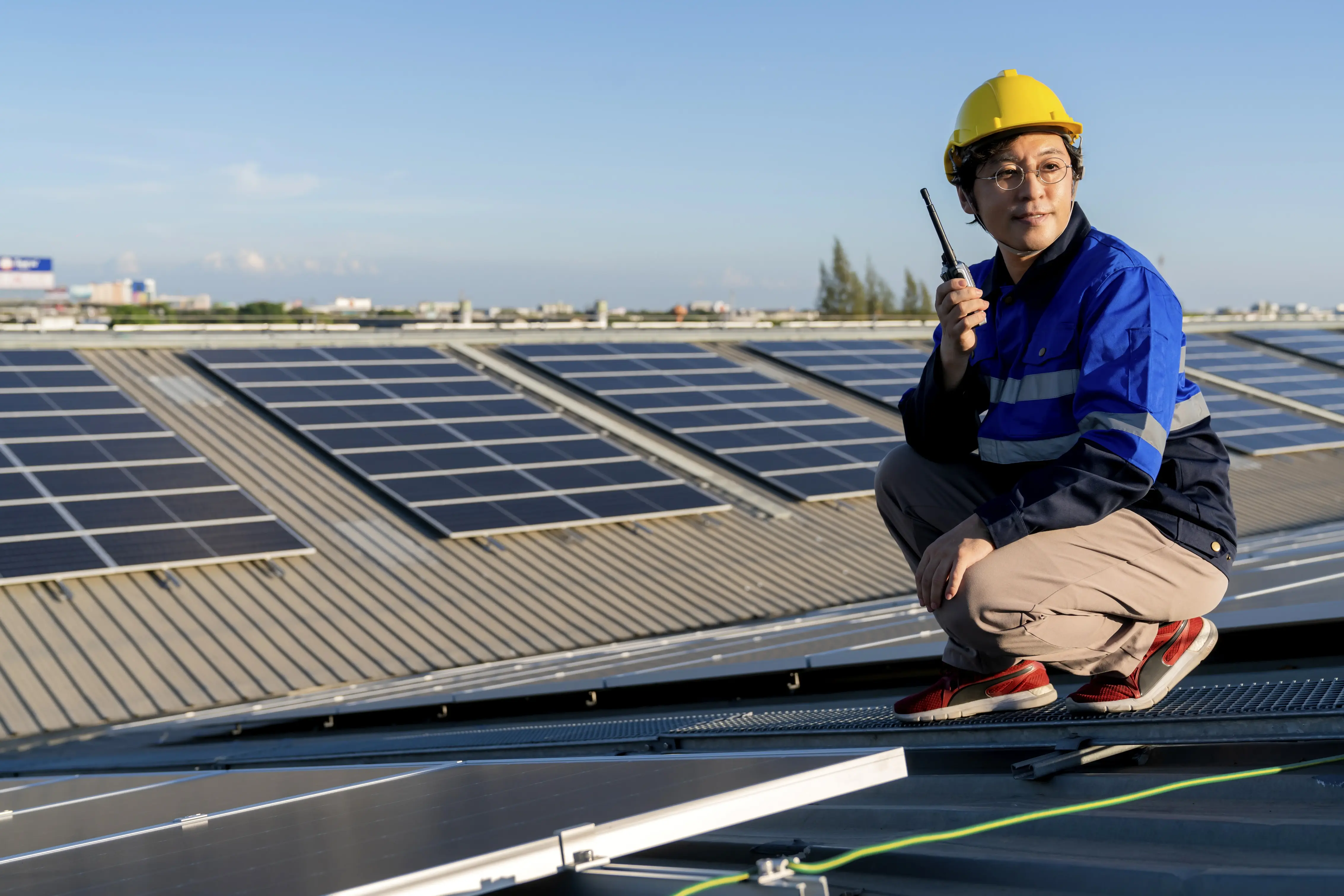 Solar technician inspecting a rooftop solar panel system during an upgrade or expansion that could affect SEG export payments and energy generation.