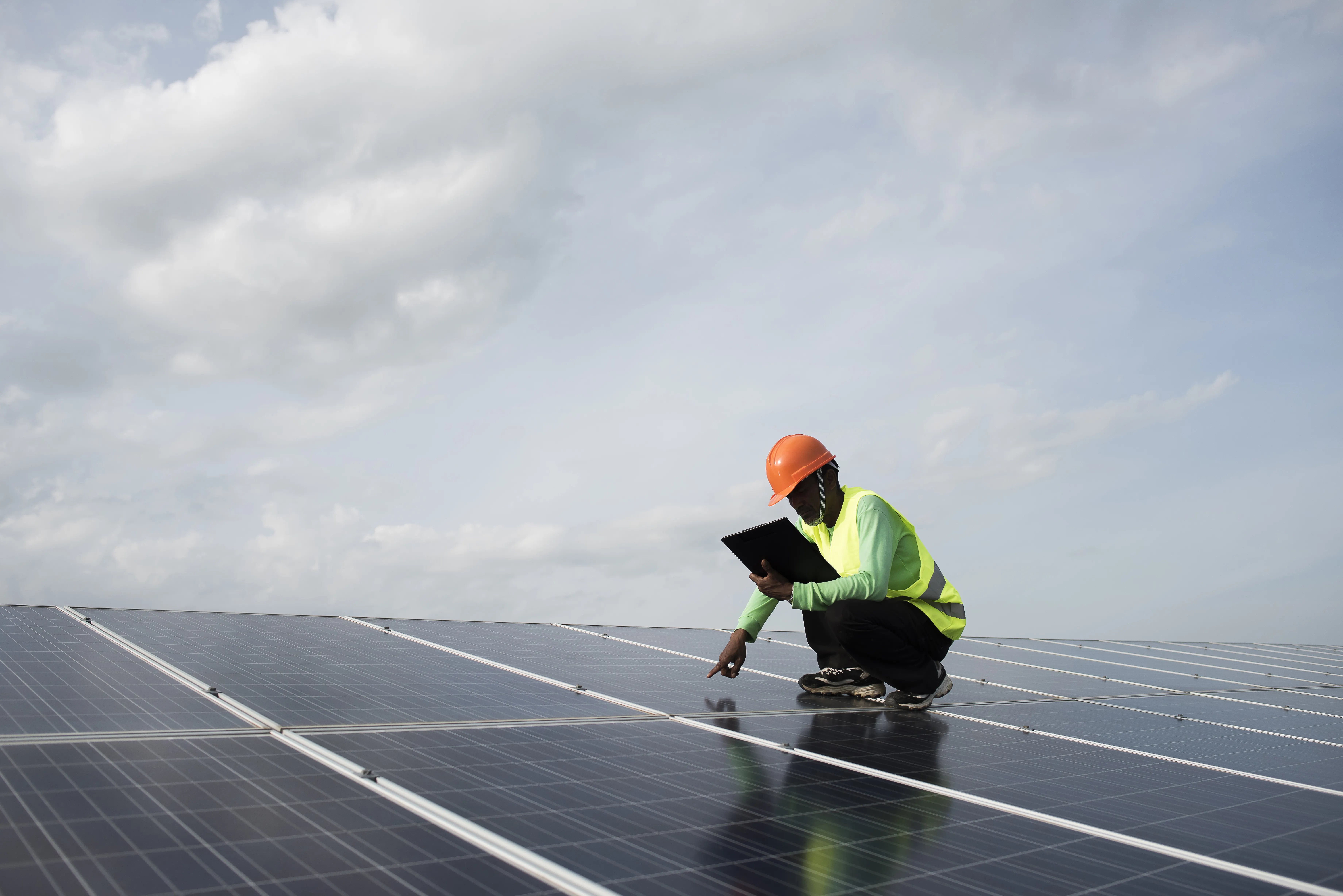 Technician inspecting rooftop solar panels to diagnose performance issues and identify faults affecting solar system efficiency.