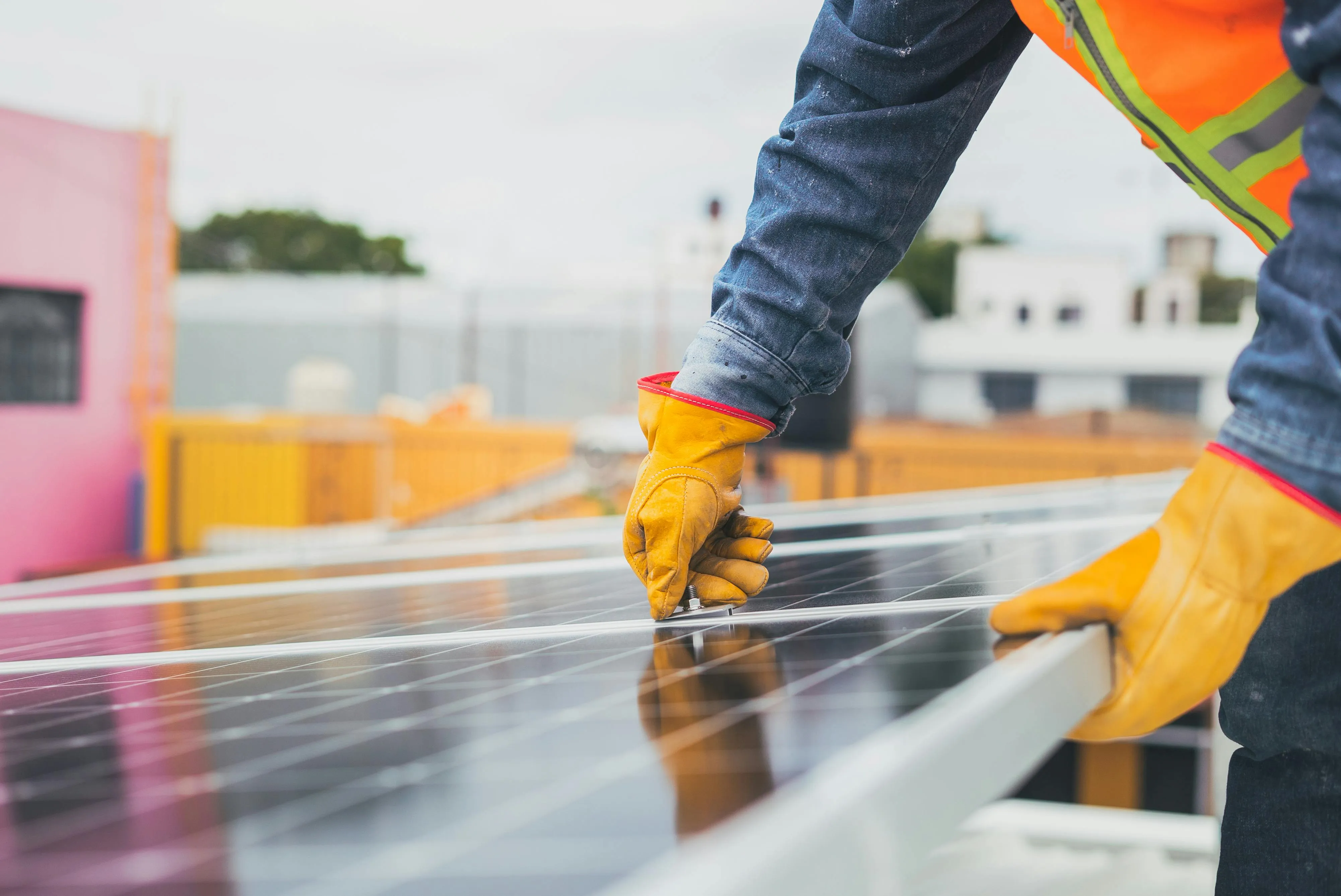 Solar technician adjusting or inspecting a rooftop solar panel installation during maintenance or system servicing. The close-up focus on hands-on work with the panel supports the article’s theme of understanding how solar systems behave during power cuts, highlighting the physical infrastructure that homeowners often assume will continue operating when the grid goes down. The image conveys professional installation, system configuration, and the importance of compatible backup equipment such as battery storage and backup-capable inverters.