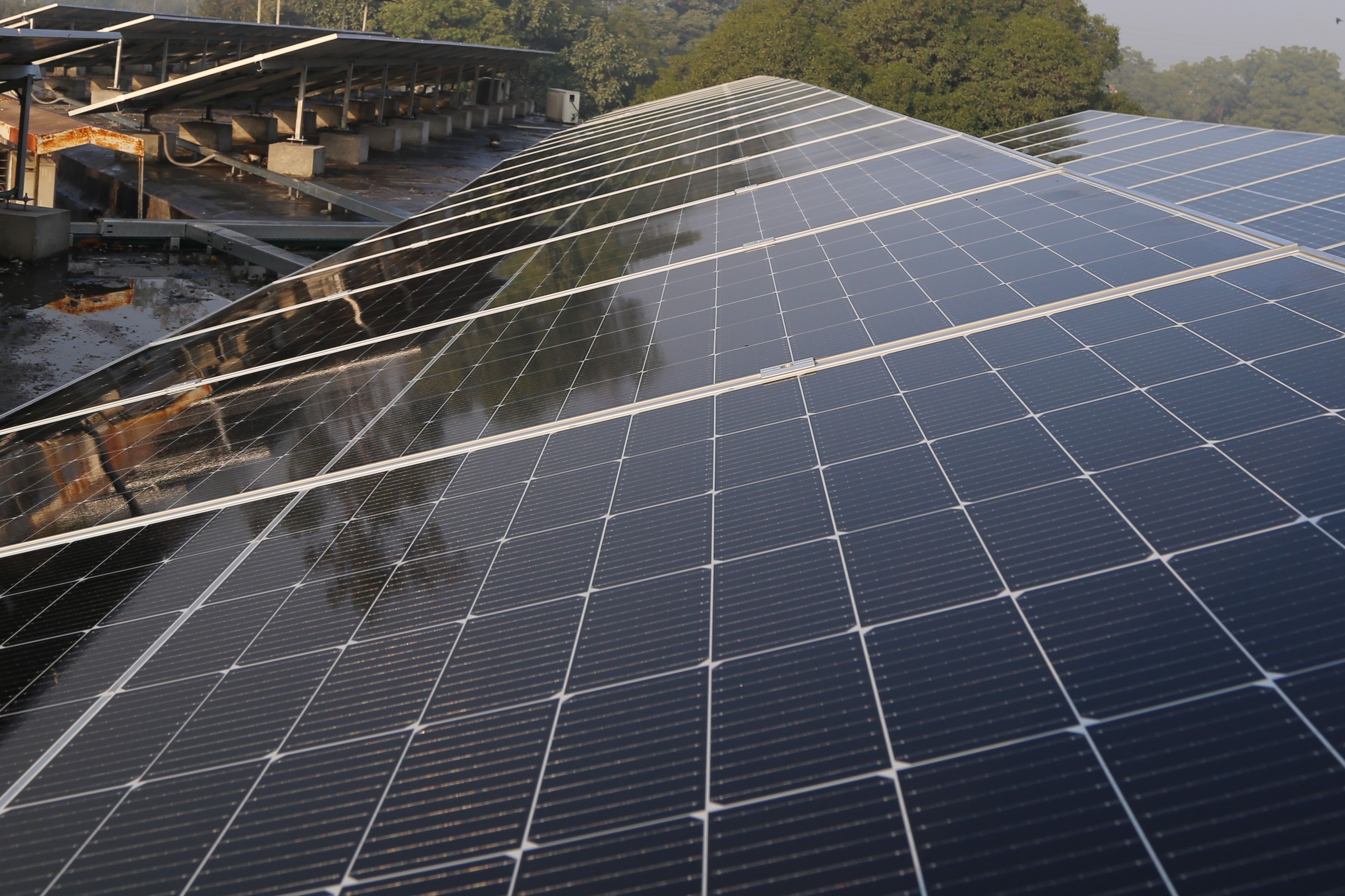 Large rooftop solar panel installation on a commercial building, generating renewable electricity as part of an energy independence and backup power strategy.