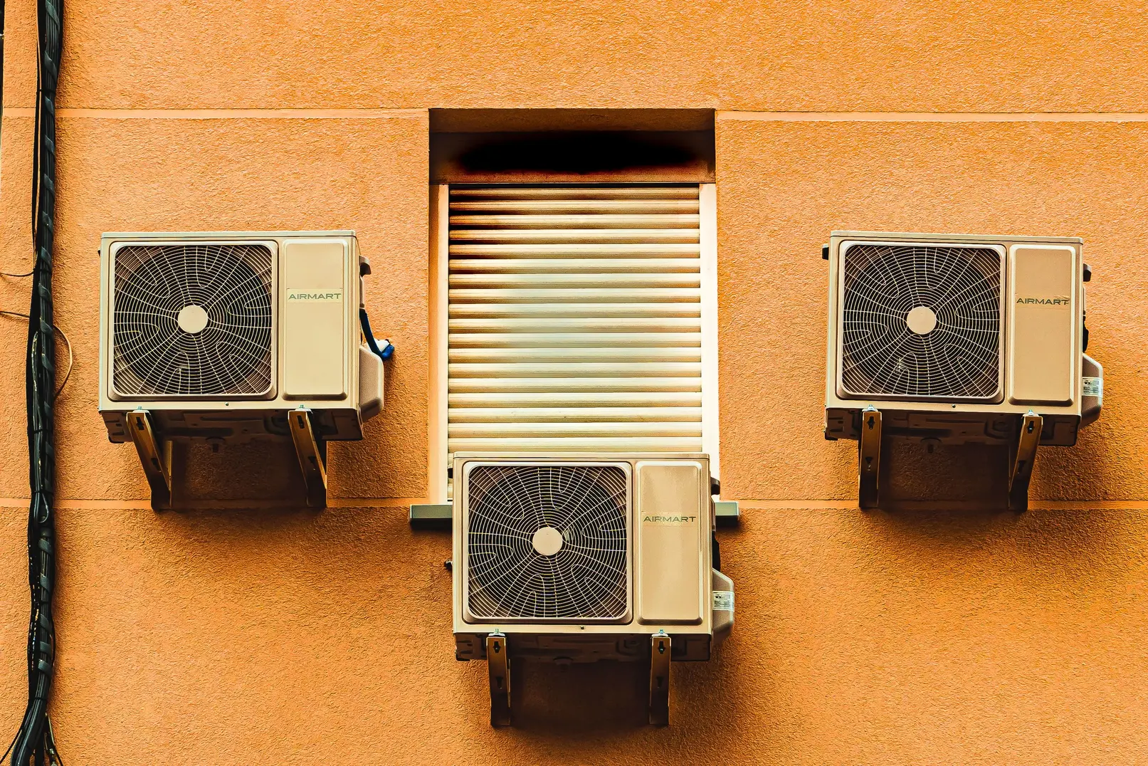 Outdoor air source heat pump unit mounted on the exterior wall of a home, illustrating a low-carbon heating system for Sussex homeowners comparing heat pumps with gas boilers.